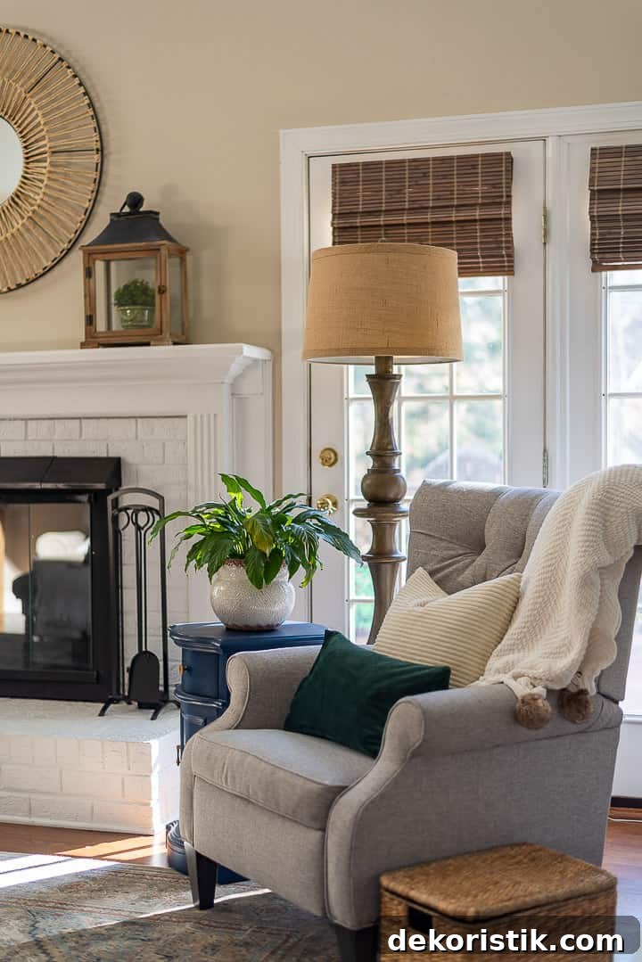 gray chair, floor lamp, blue side table sitting in front of windows and beside a white fireplace