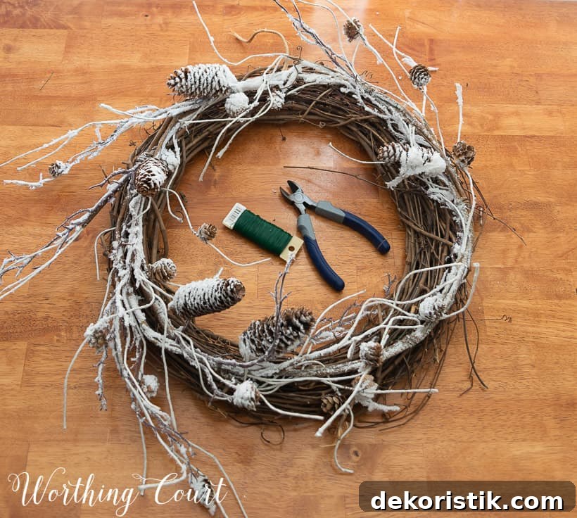 grapevine wreath, snowy garland, faux pine pieces and ribbon