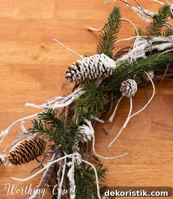 close up of snowy pinecones and pine branches on a grapevine wreath