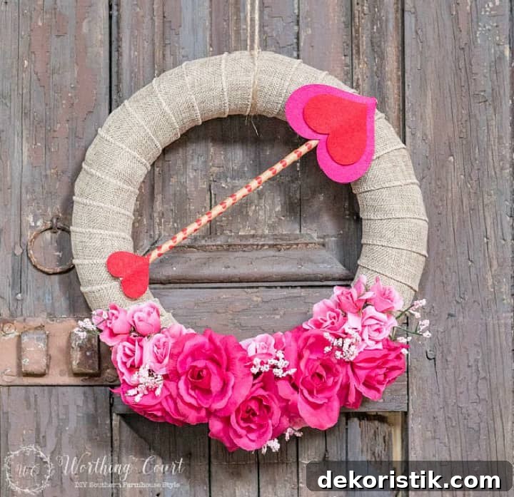 Valentine's wreath with pink and red flowers and a Cupid's arrow