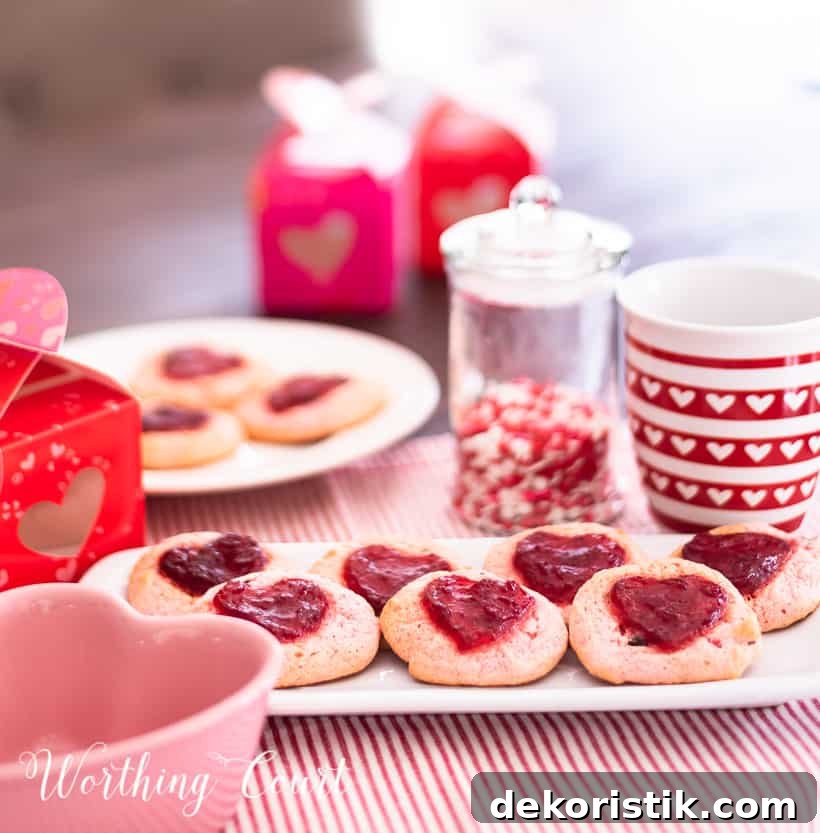 strawberry cookies on a white plate staged with other red and white items for Valentine's Day