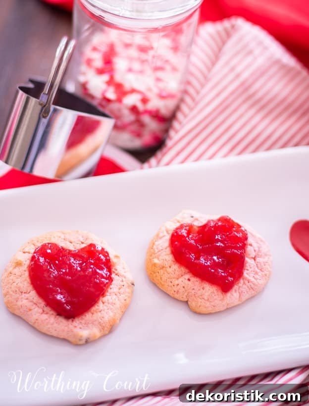 strawberry cookies on a white plate staged with other red and white items for Valentine's Day
