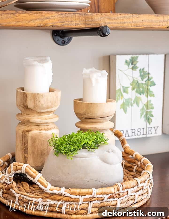 vignette with wood candlesticks and a concrete bunny in a round basket tray