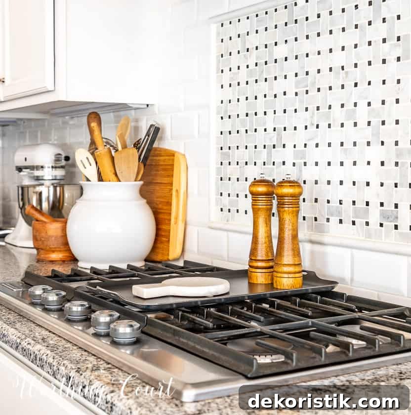 wood salt and pepper mill and marble spoon rest on top of burner griddle and other decorative items on countertop