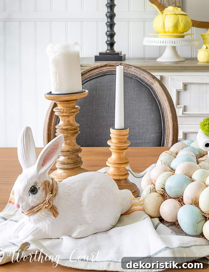 White ceramic bunny and wood candlesticks with white candles in an Easter centerpiece