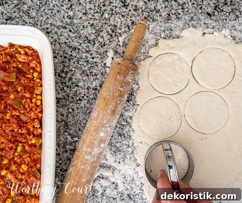 In process photo of making image of sloppy joe casserole topped with biscuits