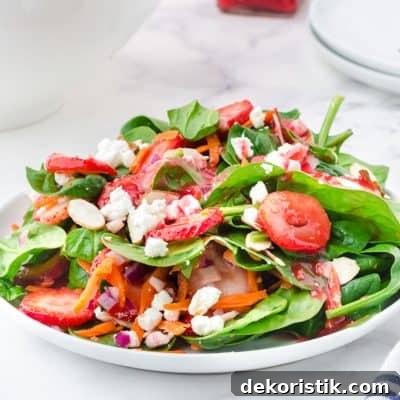 strawberry spinach salad in white bowls
