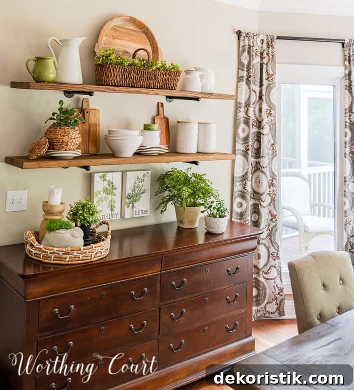 Open shelves decorated for summer with wood and white accessories and faux greenery.