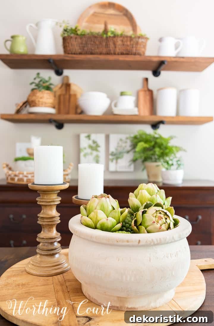 Centerpiece on a breadboard with a wooden bowl and wood candlesticks with shelves in the background