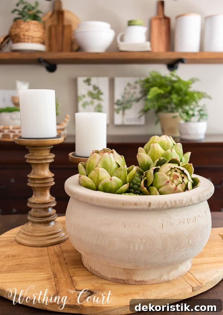 Centerpiece on a breadboard with a wooden bowl and wood candlesticks with shelves in the background