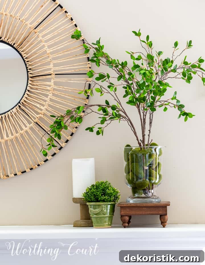 Summer mantel vignette with faux greenery and a candlestick