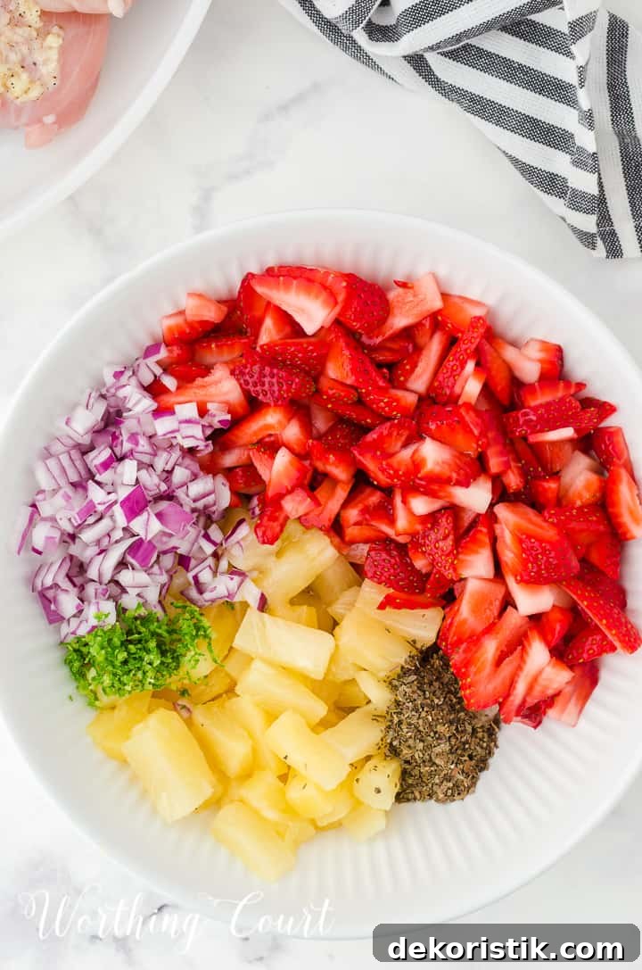 ingredients for strawberry and pineapple salsa in a white bowl