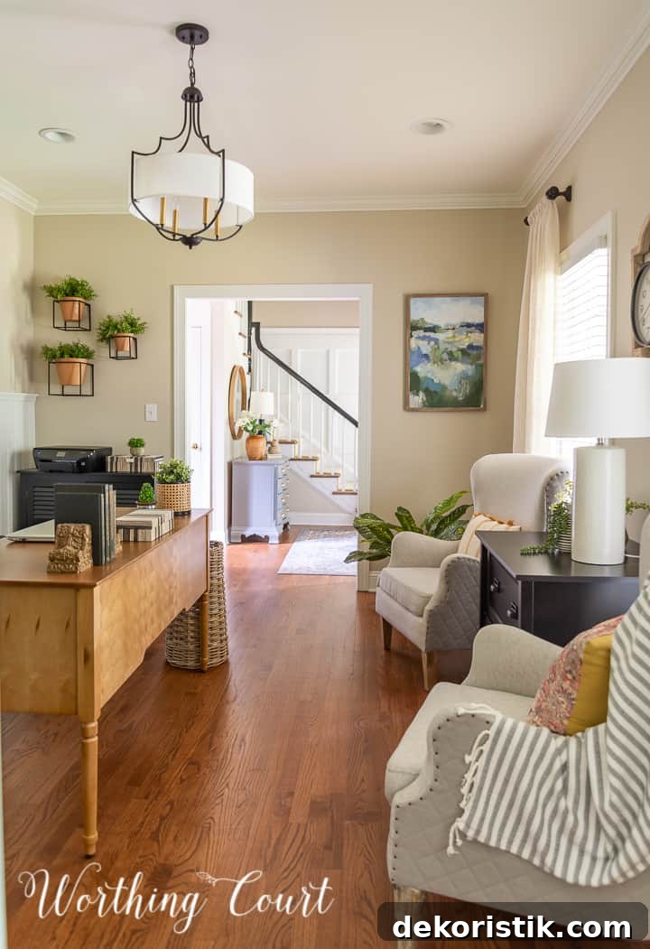 view into home office with two club chairs, natural wood toned desk and abstract wall art