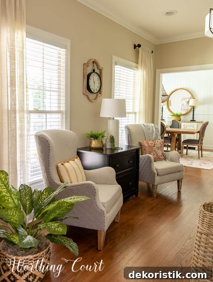 pair of club chairs in a home office with a view into the dining room