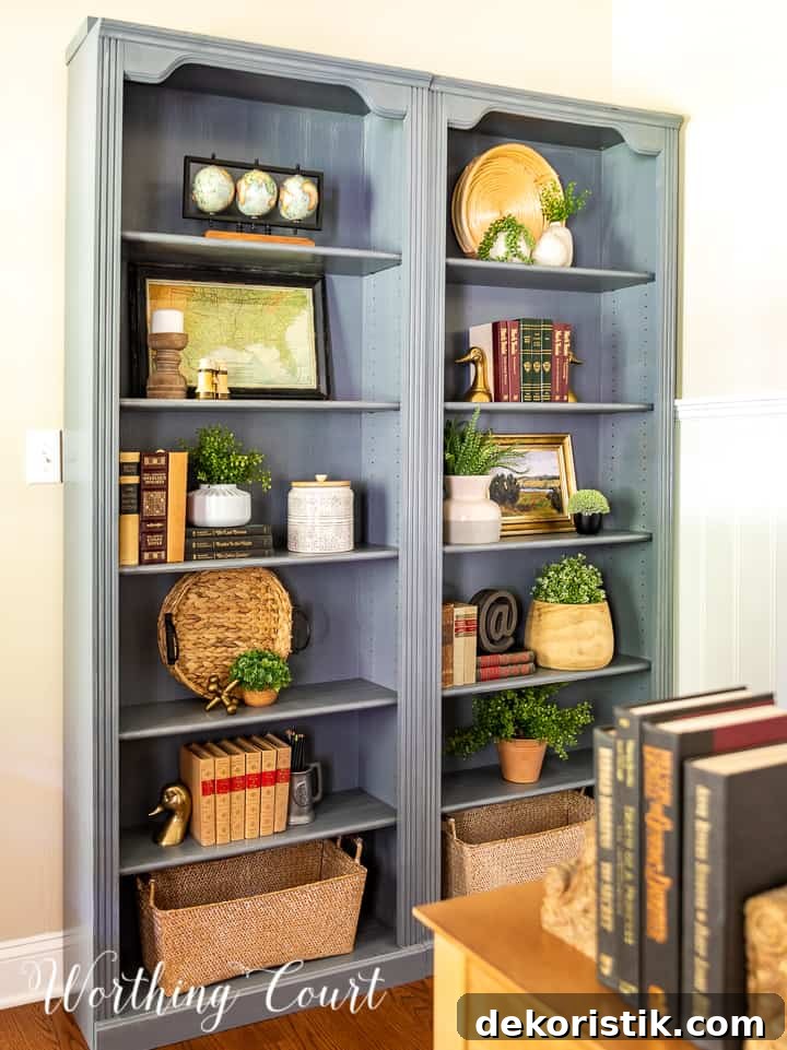 pair of gray bookcases filled with a variety of updated traditional accessories