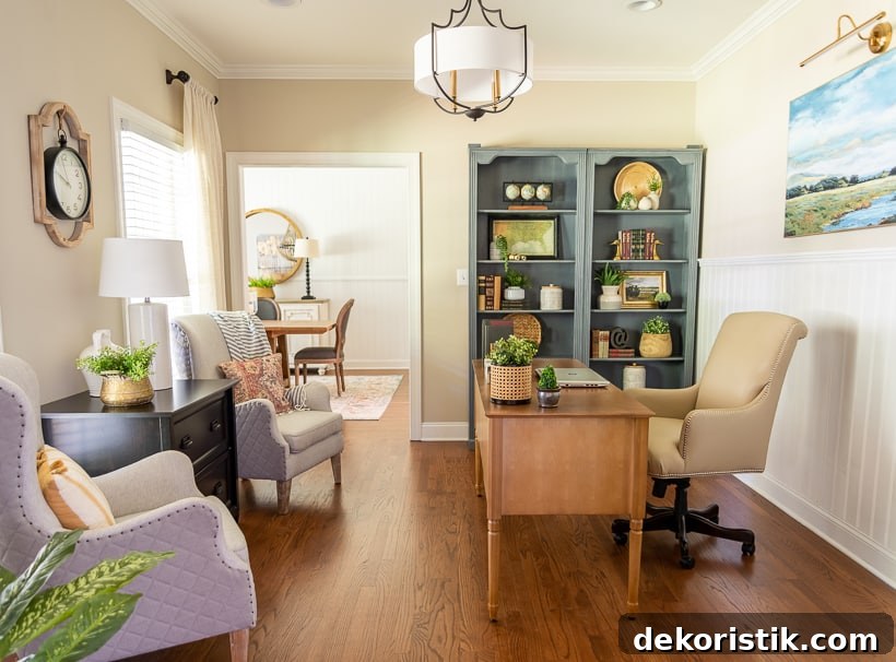 view into home office with desk, bookcases and armchairs