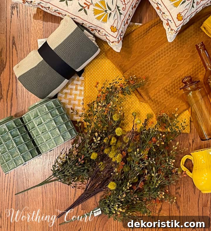 overhead view of pair of green urns, fall foliage, striped throw and yellow pillow covers on a hardwood floor