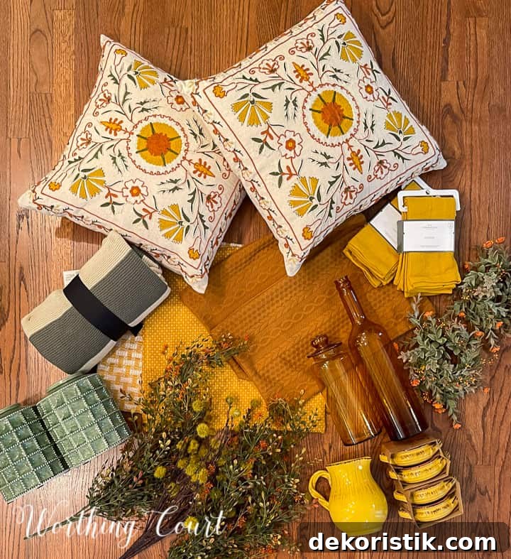 overhead view of fall decorations on a hardwood floor including pillows, foliage, dishes, pillow covers and a throw