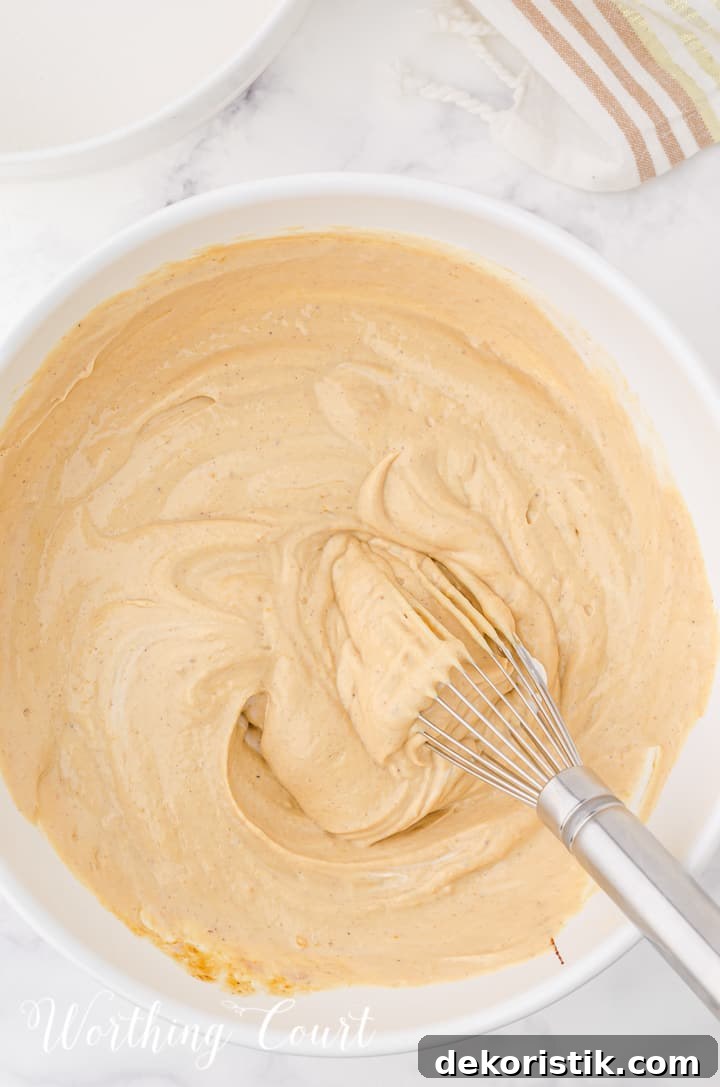 batter for gingerbread cheesecake in a white mixing bowl