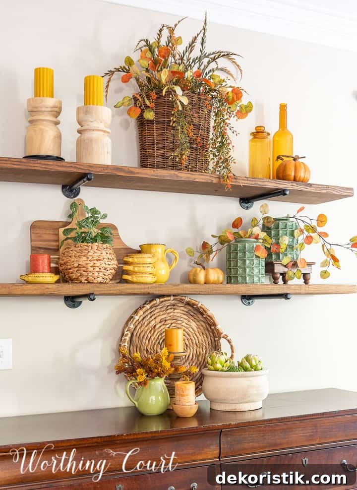 wooden open shelves decorated for fall with rich amber and green accessories