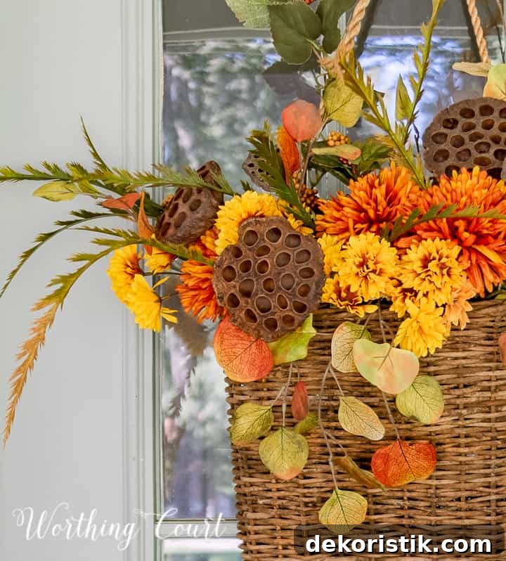 handing basket on gray front door filled with fall colored faux stems