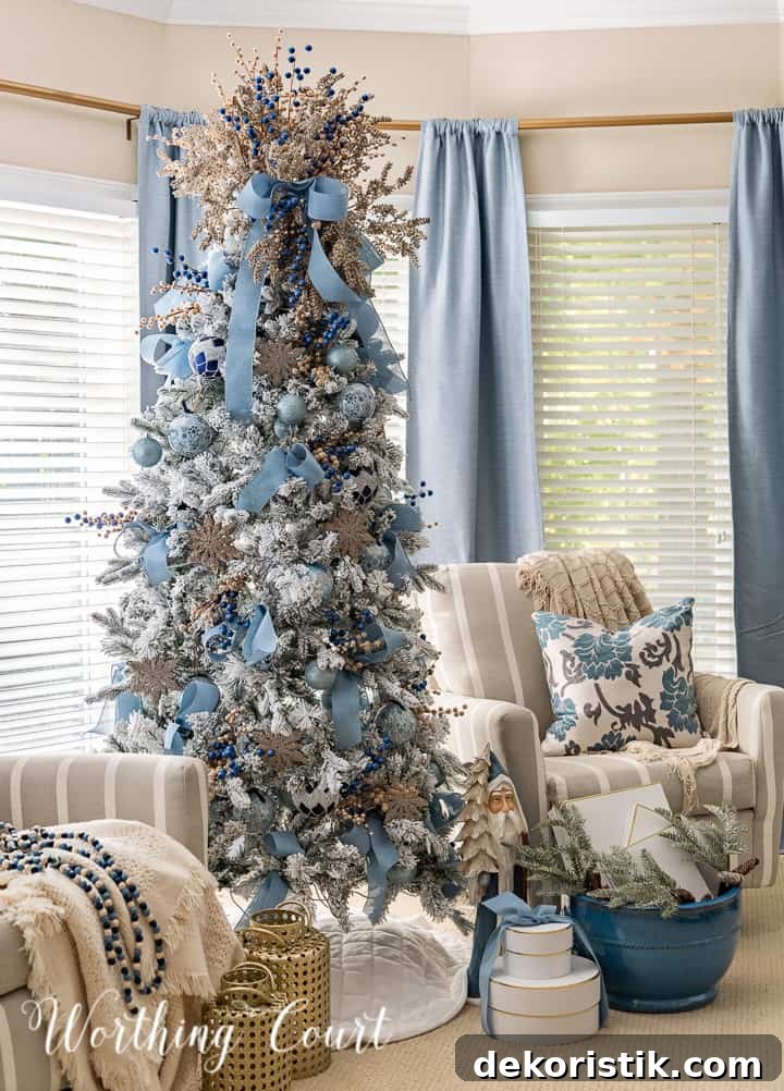 Flocked Christmas tree with blue and gold ornaments between two chairs