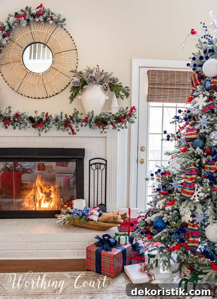 Fireplace decorated for Christmas with a garland and blue, red and white decorations sitting beside Christmas tree