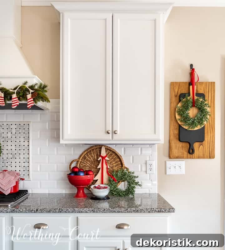 Christmas vignette on kitchen counter with white cabinets and granite counters