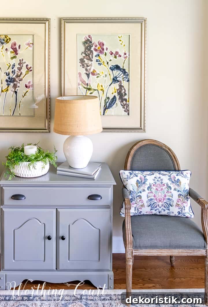 gray dining chair beside gray chest with multi colored artwork