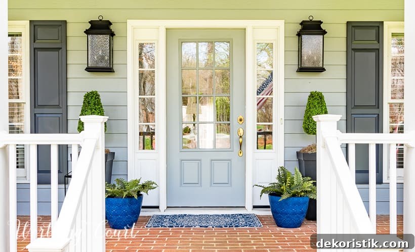 gray front door and sidelights flanked by blue planters