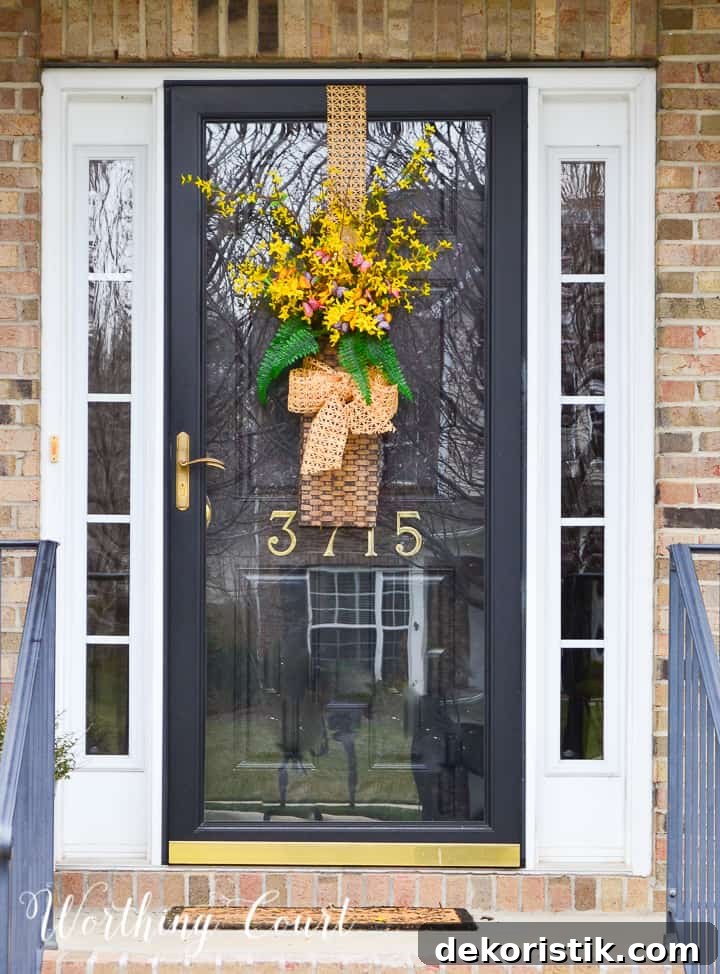 hanging basket filled with yellow flowers and greenery on a black front door