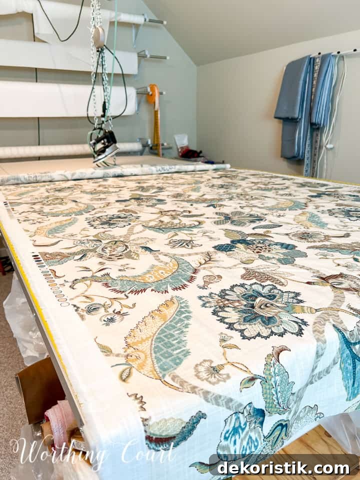 blue and white fabric spread out on a cutting table in a sewing room