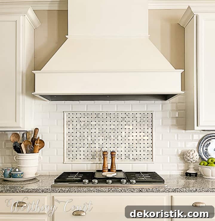 kitchen with white cabinets and large vent hood over a cooktop