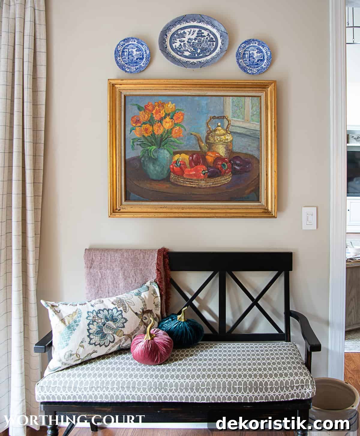 fall breakfast room and kitchen decor with an oil painting and plates hanging above a black bench