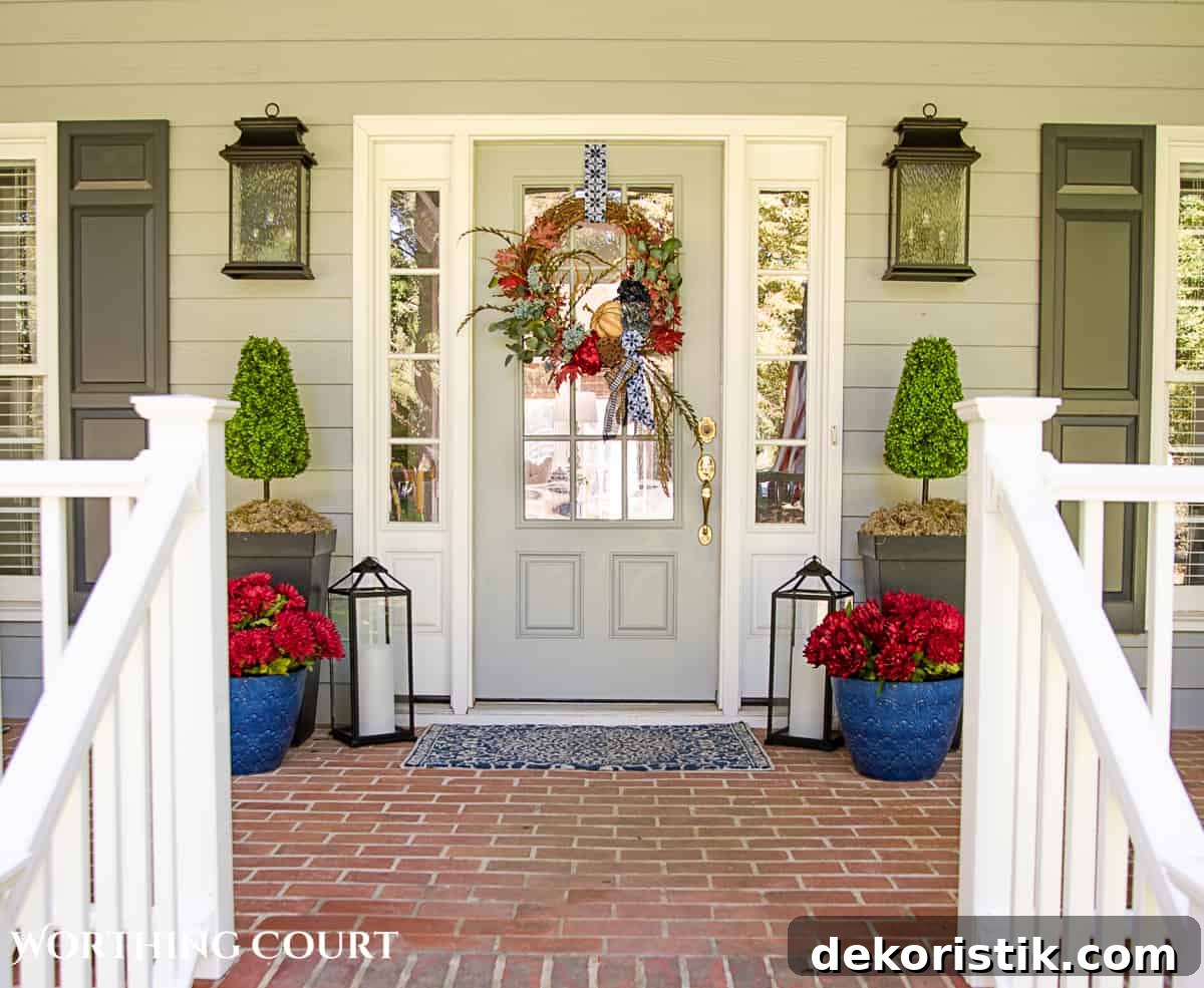 blue and burgundy fall front porch decor featuring a diy wreath, topiaries and faux mums
