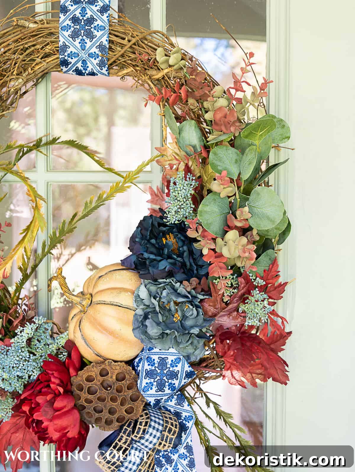 blue and burgundy fall front porch decor featuring a diy wreath, topiaries and faux mums