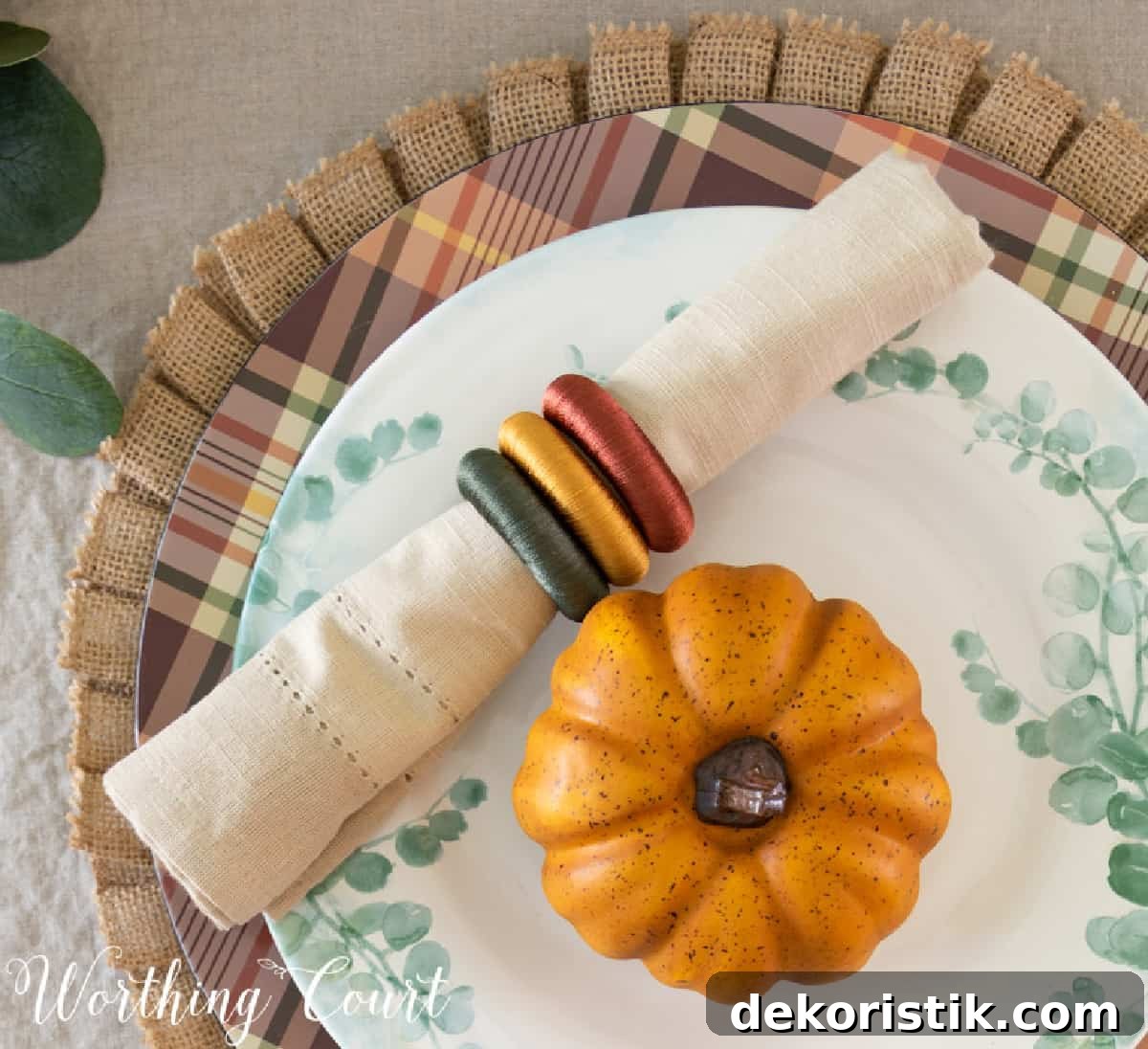 portion of thanksgiving tablescape with fall colors and eucalyptus in the centerpiece