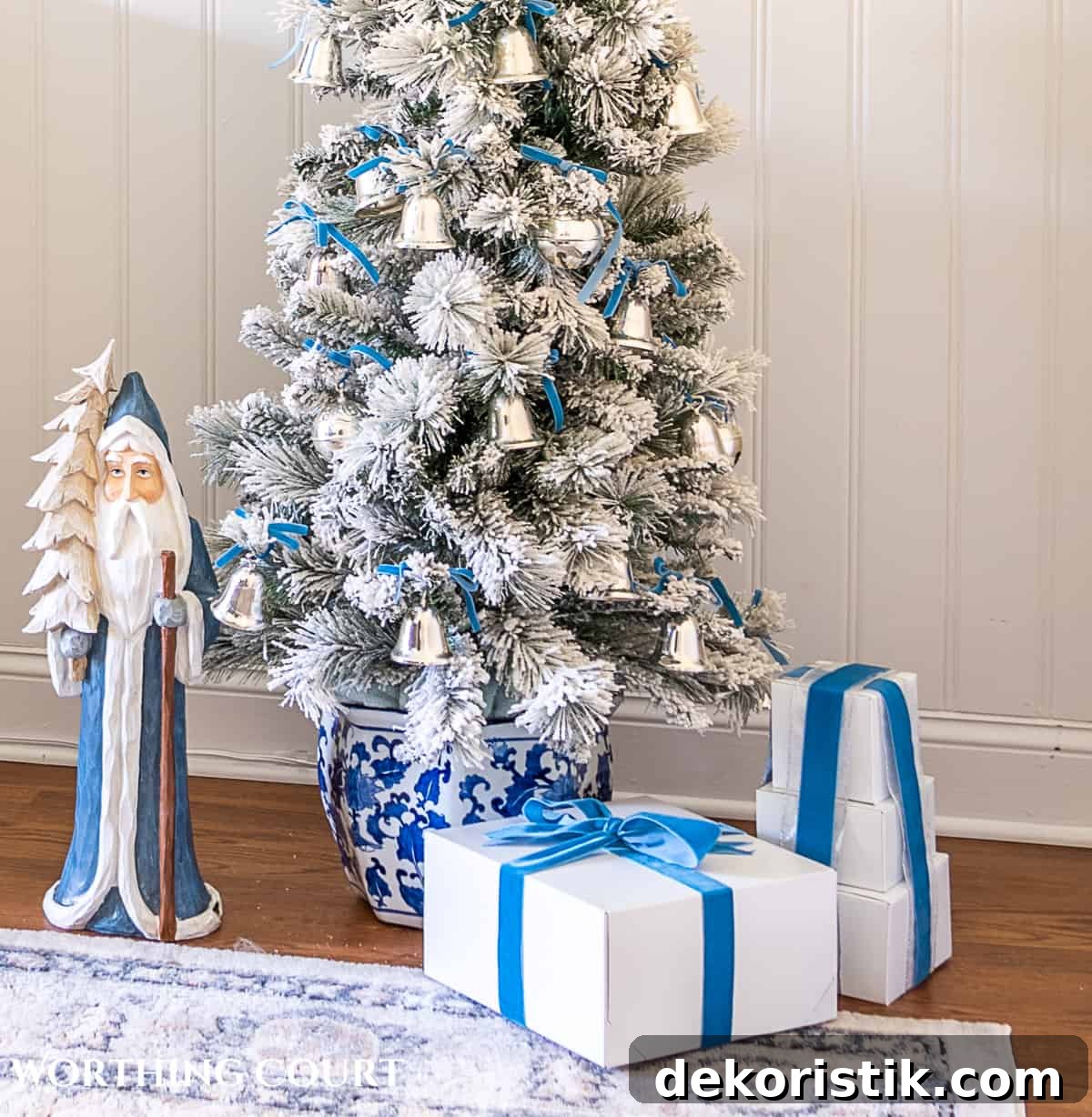 Flocked Christmas tree in blue and white porcelain container decorated with French blue and silver ornaments and ribbon