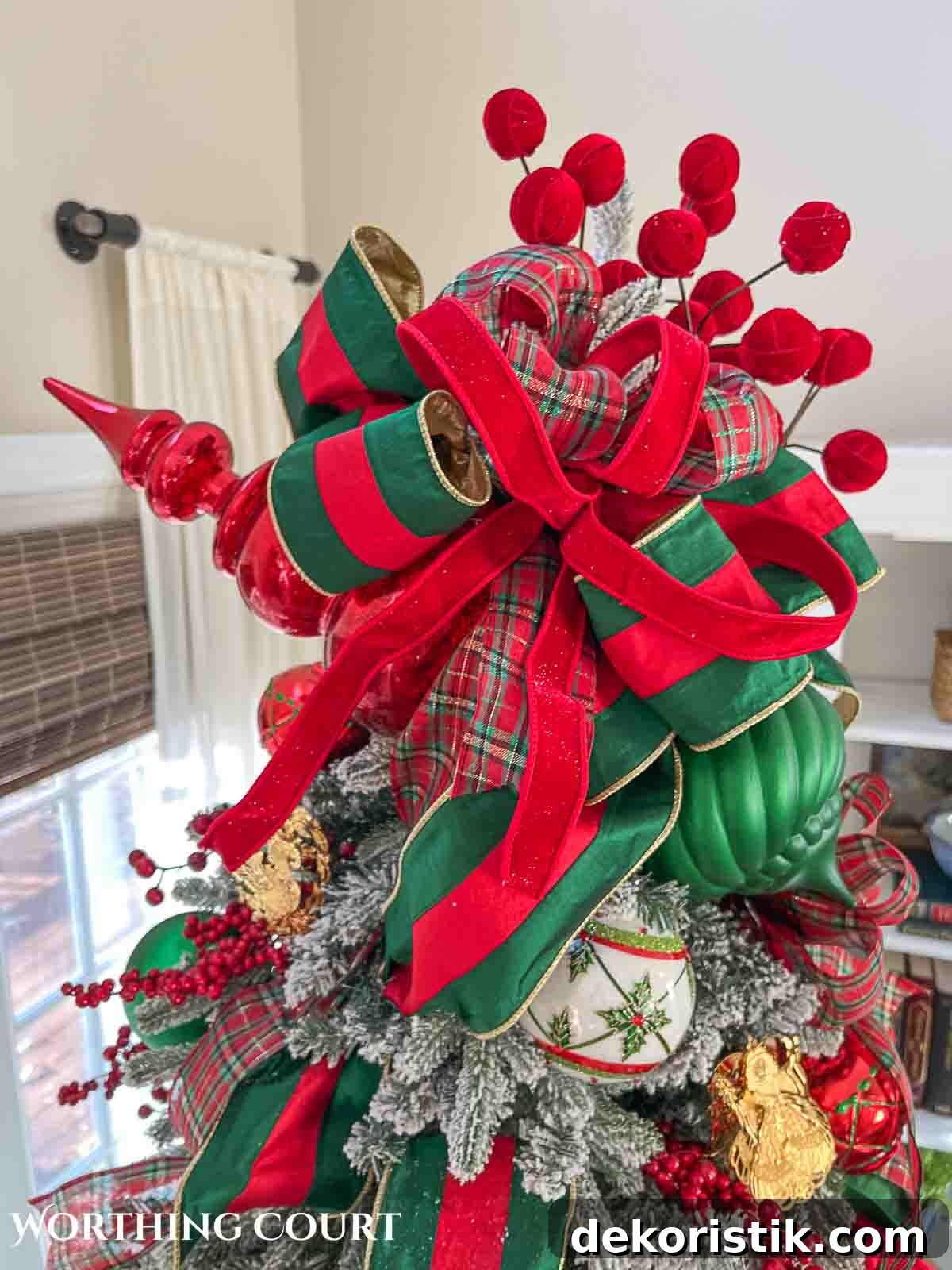 Christmas tree, fireplace and living room decorated for Christmas with red green and gold decorations