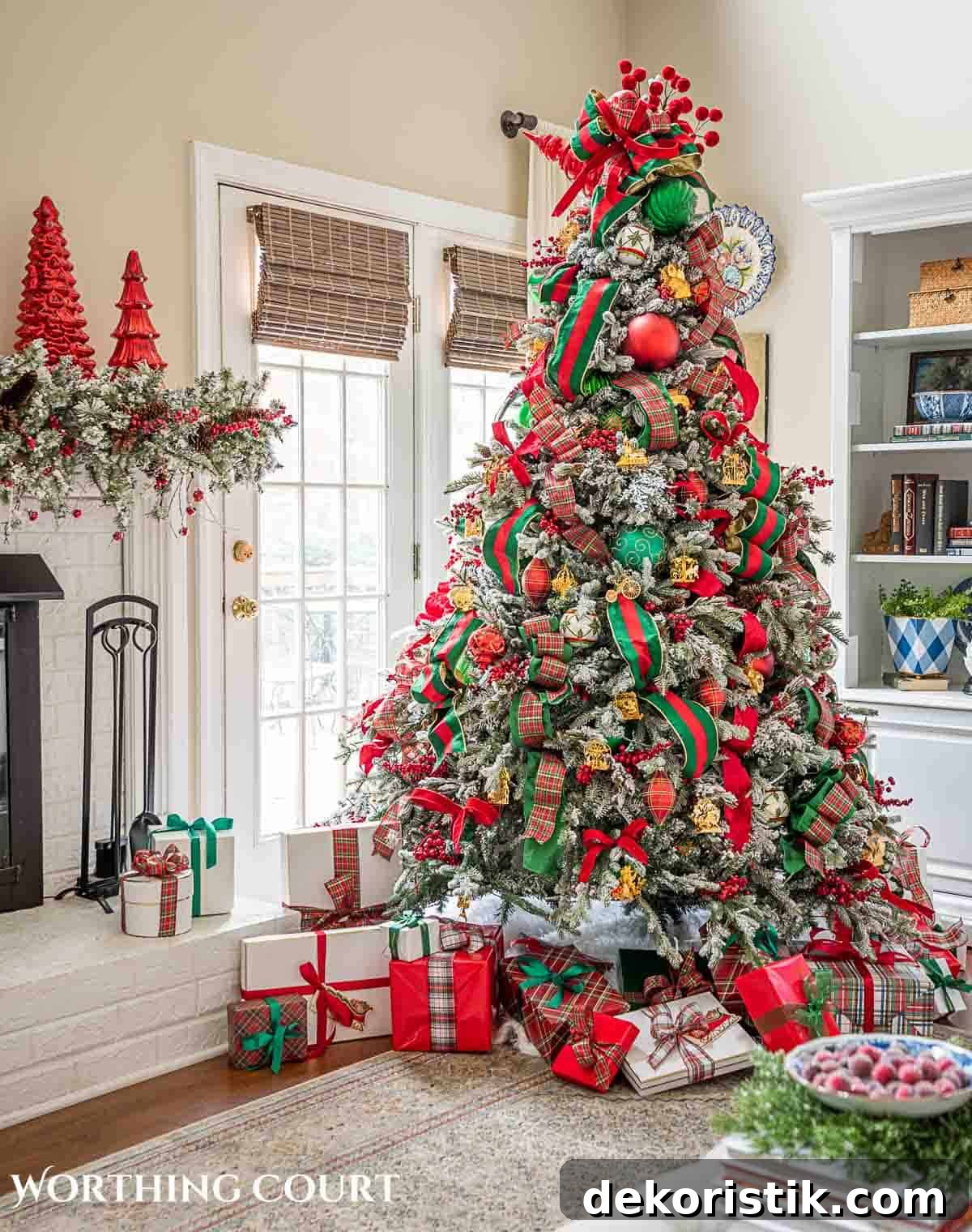 Christmas tree, fireplace and living room decorated for Christmas with red green and gold decorations