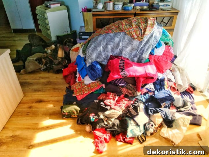 pile of clothes on the floor to sort through before organizing a closet