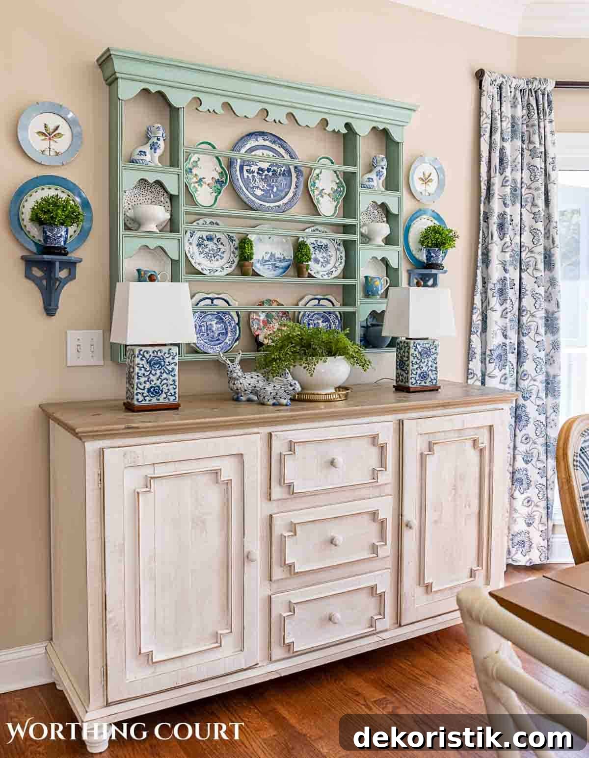 white sideboard with blue plate rack above filled with spring dishes and greenery