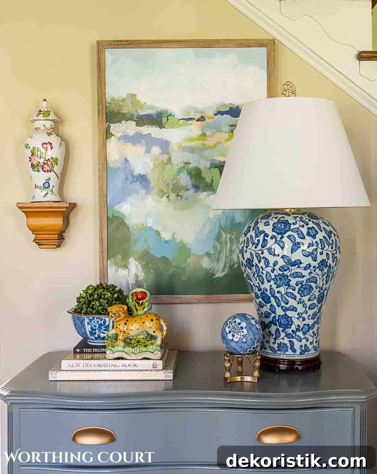 spring greenery and blue and white accessories on a gray chest