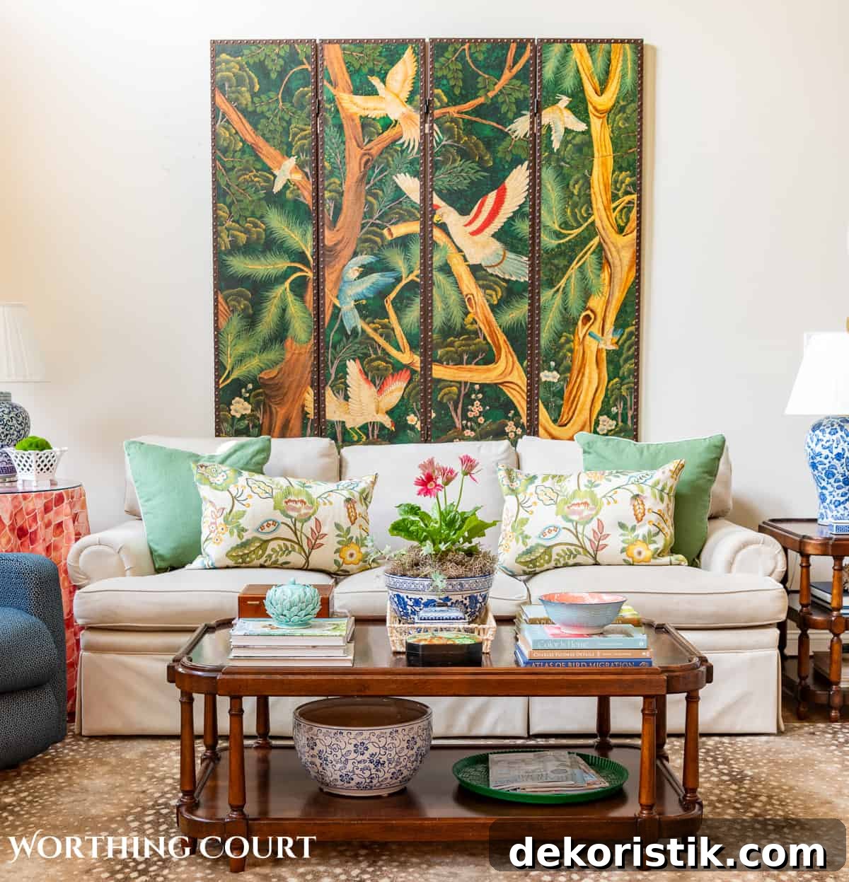 coffee table in front of tan couch with chinese screen on the wall and late summer chinoiserie accessories