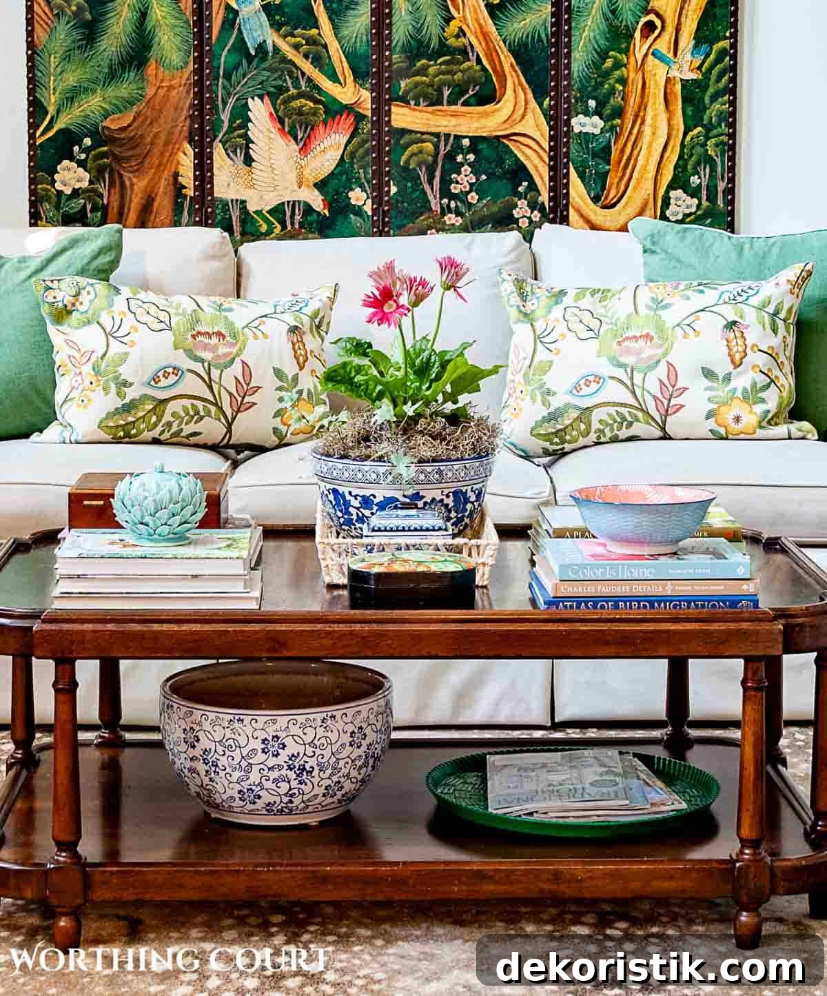 coffee table in front of tan couch with chinese screen on the wall and late summer chinoiserie accessories