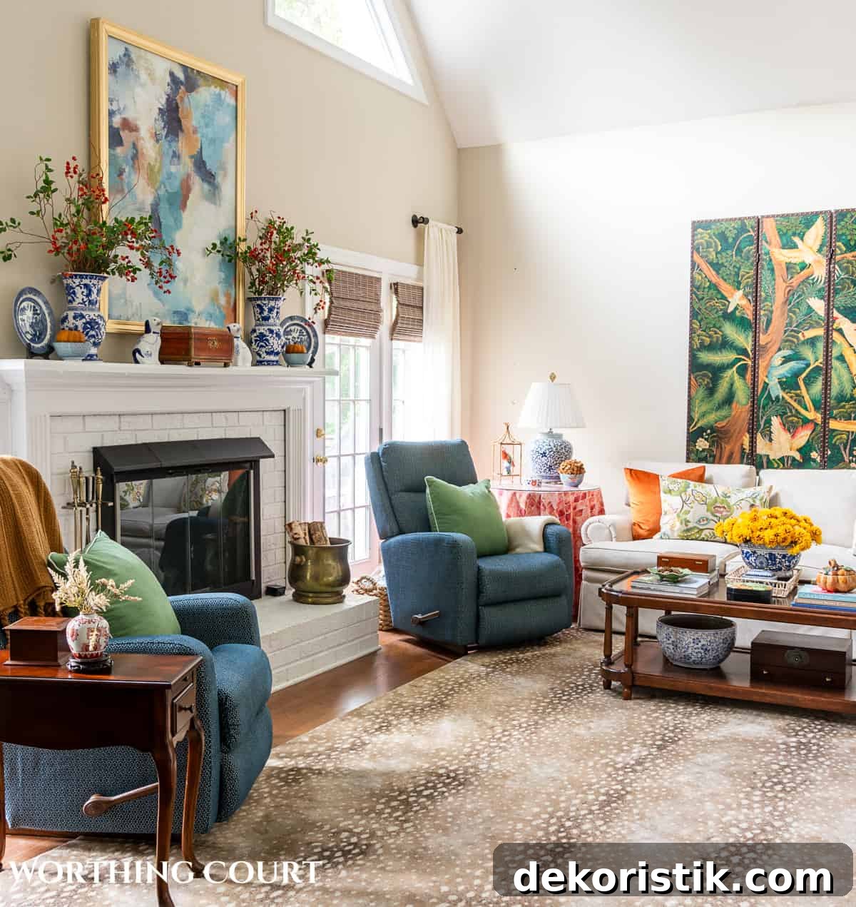 blue arm chairs flanking a white brick fireplace in a living room with fall decorations