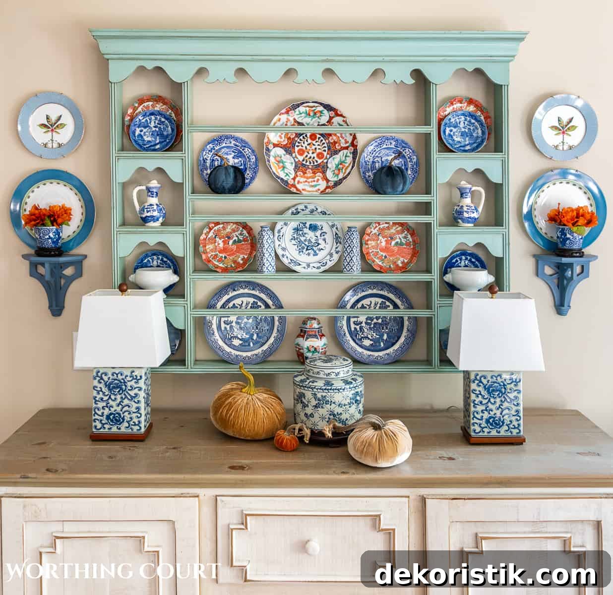 plate rack above a white sideboard filled with blue and white dishes and orange dishes for fall