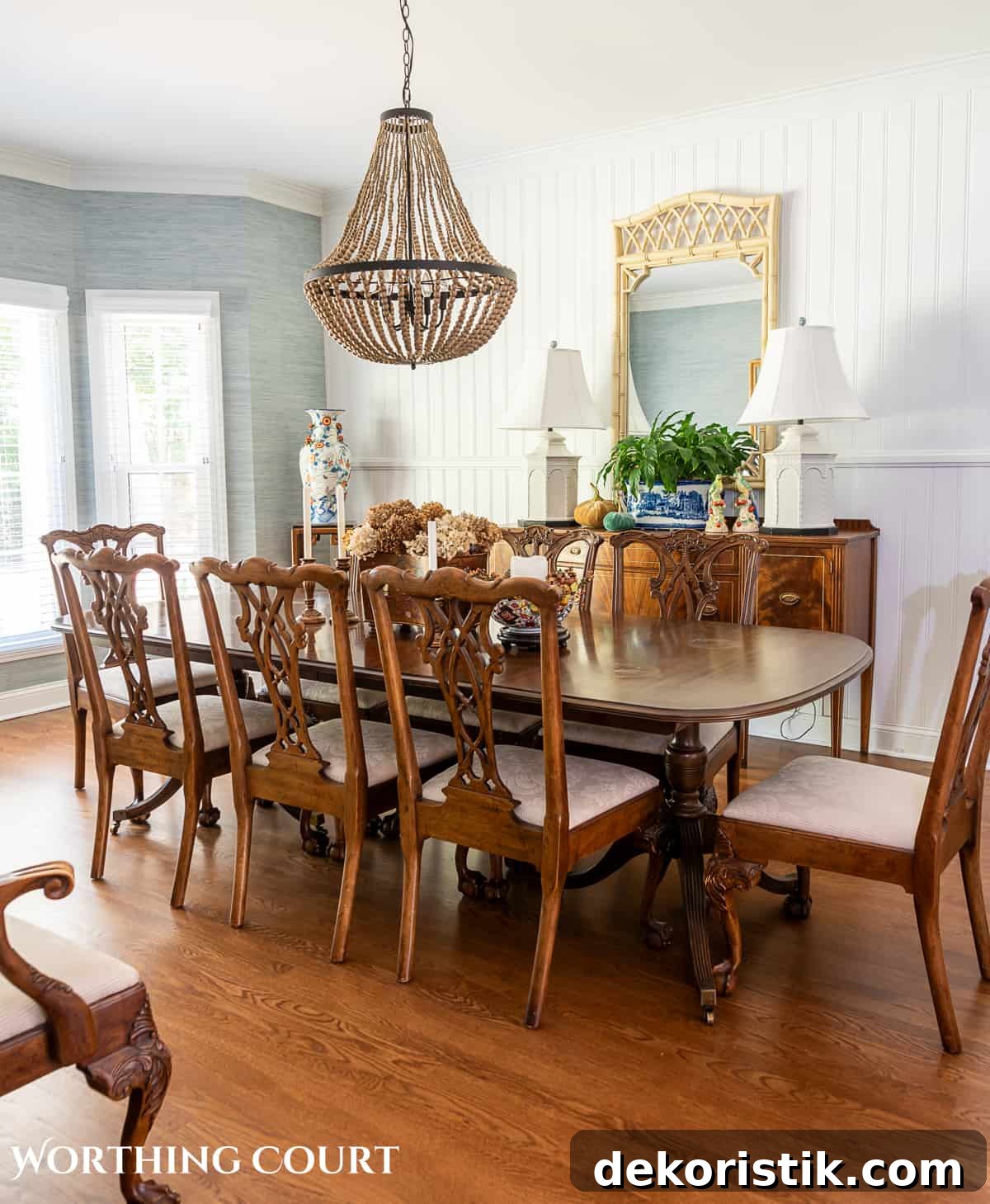 traditional dining table and chairs in a dining room with blue grasscloth wallpaper and fall decorations