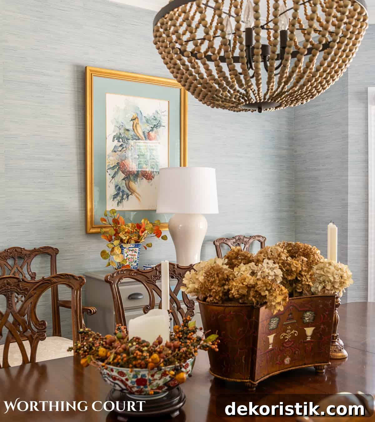 artwork hanging above a gray chest with a white lamp and diy fall decorations