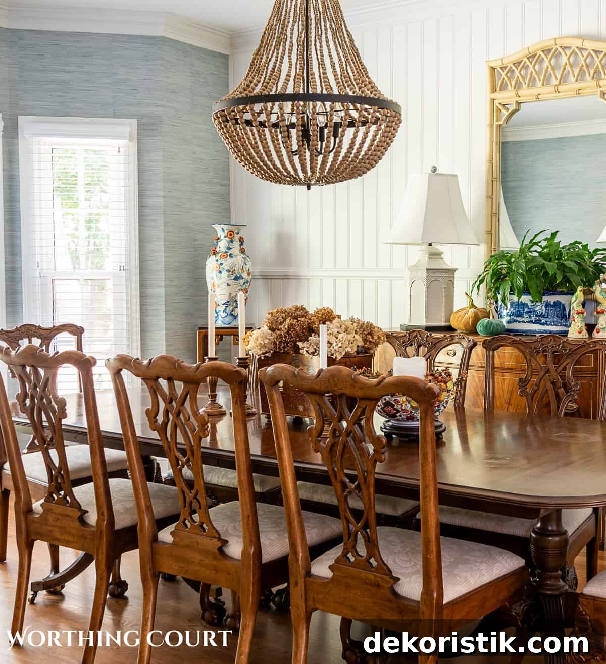 traditional dining table and chairs in a dining room with blue grasscloth wallpaper and fall decorations